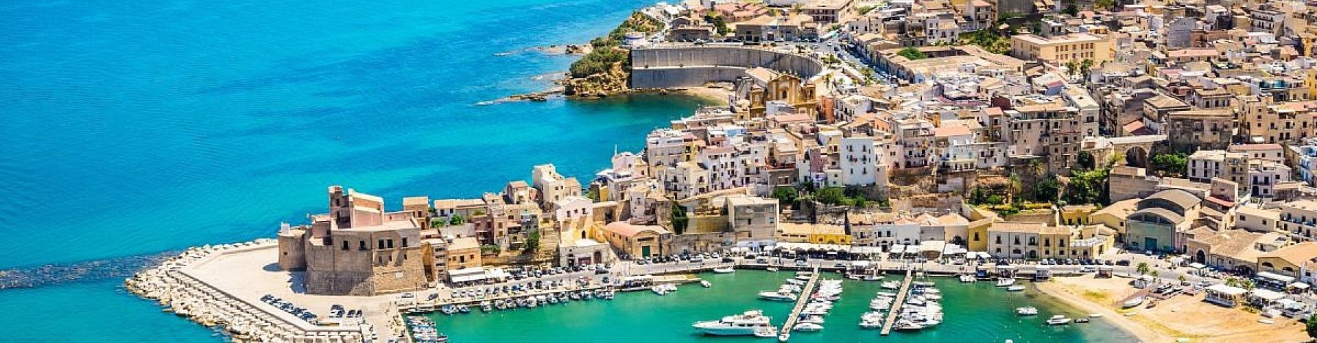 Luxury limousine parked near Sicilian coastline in Castellammare del Golfo