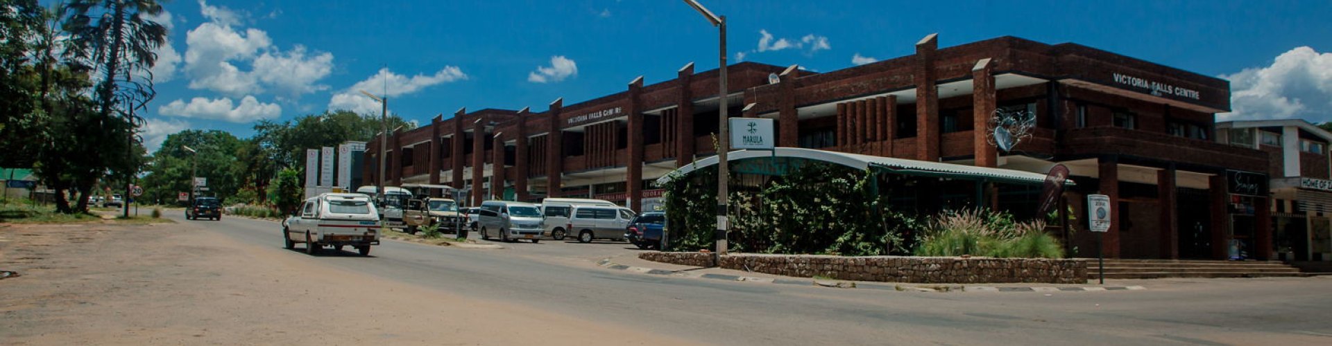 Sunset view over Victoria Falls with luxury vehicle silhouette